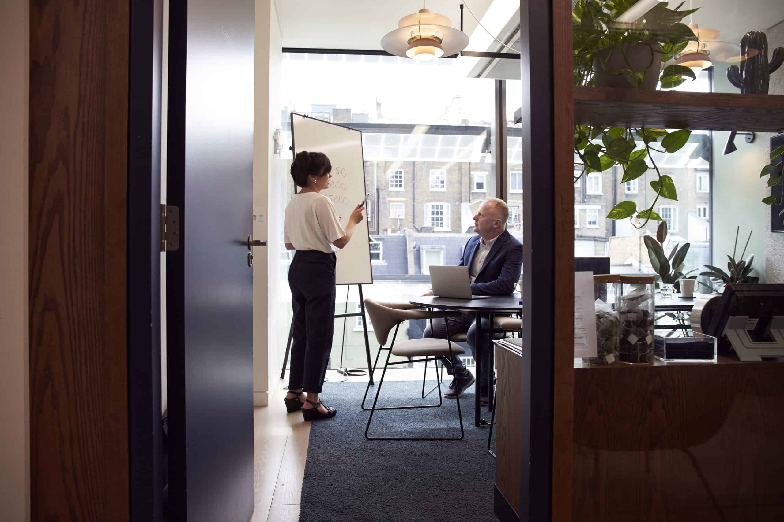 stock image showing a woman talking to a man in an office about a marketing audit
