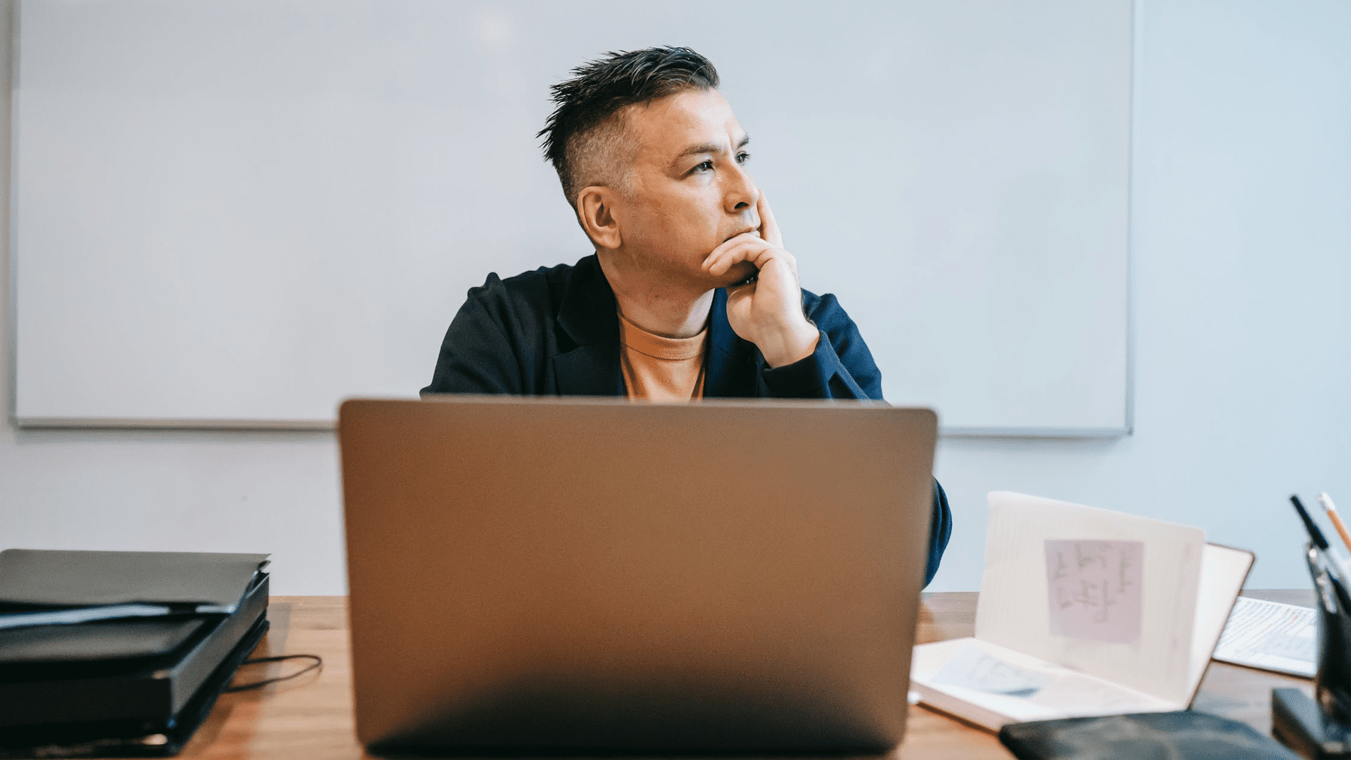 stock image showing a man in front of a laptop thinking about why a good marketing strategy takes time